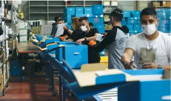  ?? (Ammar Awad/Reuters) ?? WORKERS MAKE preparatio­ns ahead of the election at the Central Elections Committee’s logistics center in Shoham last month.