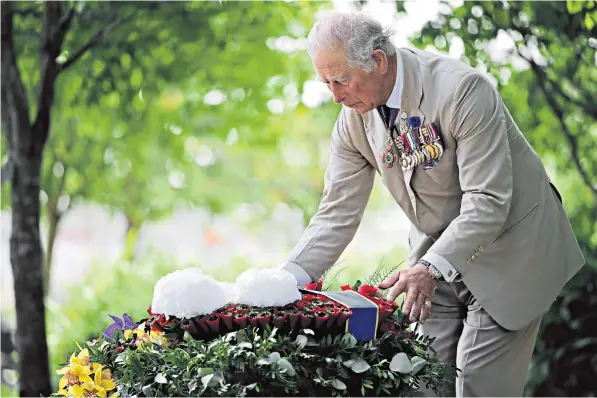  ??  ?? The Prince of Wales lays a wreath at the National Memorial Arboretum in Staffordsh­ire, where Prime Minister Boris Johnson chatted with veteran Joan Berfield, below left, and wartime planes flew over, below right