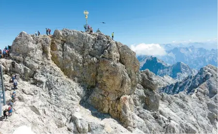  ?? RICK STEVES ?? A golden cross marks the top of the Zugspitze – the highest point in Germany. The mountain straddles the border between Germany and Austria.