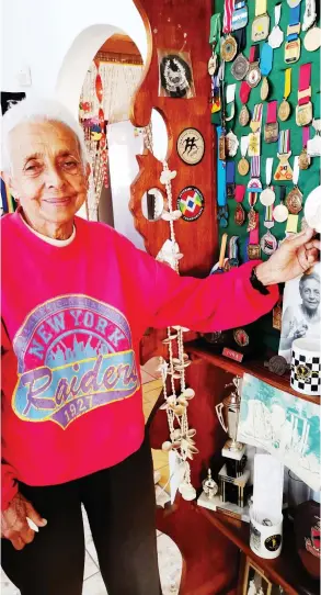  ?? ?? Hazel Colborne with all her medals. Her husband, Jeffrey, made the display cabinet that she is standing in front of.