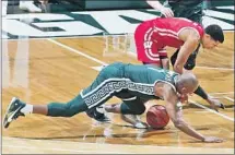  ?? WISCONSIN’S D’MITRIK TRICE Al Goldis Associated Press ?? battles Michigan State’s Joshua Langford, foreground, for the ball in the Badgers’ win.