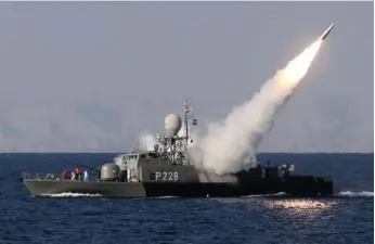  ?? EBRAHIM NOROOZI/AFP/GETTY IMAGES ?? An Iranian warship fires a missile in the Strait of Hormuz. Closing the strait could block Persian Gulf oil exports.