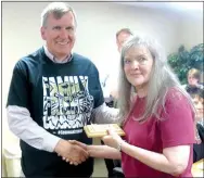  ?? Photo by Susan Holland ?? Jay Oliphant, president of the Gravette School Board, presented Julia Amos a plaque at the May school board meeting honoring her as classified staff member of the year.