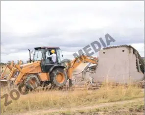  ??  ?? A bulldozer razed houses rendering at least 10 families homeless at Juru Growth Point on Tuesday