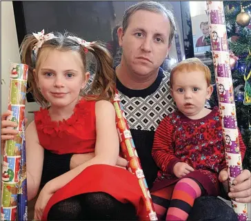  ??  ?? Rip-off: Dean Baker and daughters Eden, seven, and Harriet, 18 months, with the gift wrap