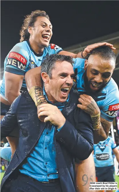  ??  ?? NSW coach Brad Fittler is swamped by his players after their win in Origin II.