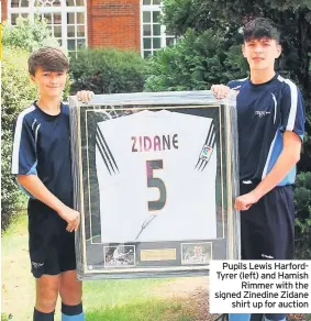  ??  ?? Pupils Lewis HarfordTyr­er (left) and Hamish Rimmer with the signed Zinedine Zidane shirt up for auction