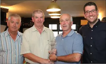  ??  ?? The Phyllis O’Riordan golf trophy is presented to John Kehoe at the Three Bullet Gate, New Ross, by Ger O’Riordan and Bob O’Riordan, with Society Captain David Lee on the right.