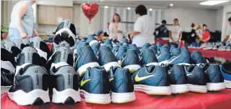  ?? DAVE JOHNSON THE WELLAND TRIBUNE ?? Sneakers are lined up on a table at The Hope Centre during Snacks n' Sneakers Day at the Welland agency. Children aged four to 18 years old were able to pick up a brand new pair of shoes, socks and a bag full of snacks.