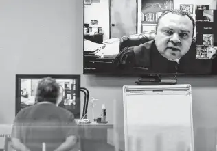  ?? William Luther / Staff photograph­er ?? Precinct 4 Justice of the Peace Rogelio Lopez appears on a screen while a landlord listens during a hybrid online/in-person eviction hearing Wednesday.