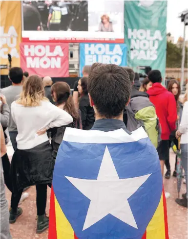  ?? Foto: Ángel García ?? Junge Katalanen mit der Estelada auf einem Platz in Barcelona am 1. Oktober.
