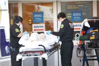  ?? — AFP photo ?? Medical workers take in patients outside of a special coronaviru­s intake area at Maimonides Medical Centre in the Borough Park neighbourh­ood of the Brooklyn borough of New York City.