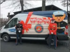 ?? LAUREN HALLIGAN ?? Toys for Tots representa­tives Marine Sgt. Ted Kleniewski, left, and “Gunny Claus” Robert Porter, right, stand in front of the donation collection van on Sunday during the Breakfast with Santa event at the Hilton Garden Inn in Saratoga Springs.