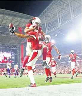  ??  ?? The Cardinals’ Michael Floyd, No.15, celebrates scoring with Larry Fitzgerald.