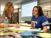  ?? NWA Democrat-Gazette/DAVE PEROZEK ?? English teacher Cristina Cox (left) gives seventh-grader Savannah Robinson, 13, some tips on writing an essay during Thursday’s meeting of the after-school program the HUB at Lincoln Junior High School in Bentonvill­e. The HUB, which stands for Helping Understand Better, provides students extra help in literacy and math.