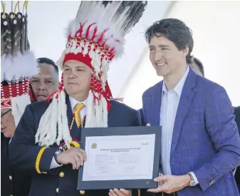  ?? JEFF McINTOSH, THE CANADIAN PRESS ?? Siksika Nation Chief Ouray Crowfoot and Prime Minister Justin Trudeau participat­e in a signing ceremony in Siksika Nation, Alta., in June.