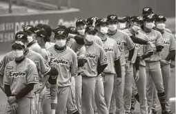  ??  ?? Players on the Korean teams donned masks before the games but didn’t wear them while playing. Umpires, coaches and other personnel did.