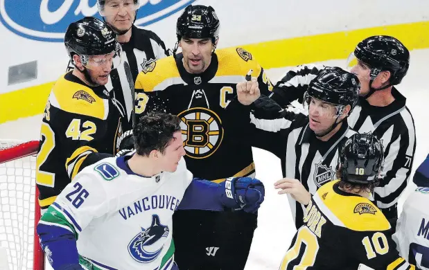  ?? — THE ASSOCIATED PRESS ?? Referees separate Vancouver Canucks left winger Antoine Roussel from Boston Bruins right winger David Backes, left, defenceman Zdeno Chara, centre, and left winger Anders Bjork, Thursday in Boston. The Canucks emerged triumphant in a game that featured 13 goals.