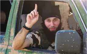  ?? (Reuters) ?? AN ISIS FIGHTER gestures in 2014 in the countrysid­e of the Syrian Kurdish town of Kobani, after the terrorist group took control of the area.