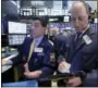  ?? RICHARD DREW — THE ASSOCIATED PRESS ?? Specialist Peter Mazza, left, and trader Gordon Charlop work on the floor of the New York Stock Exchange on Thursday.