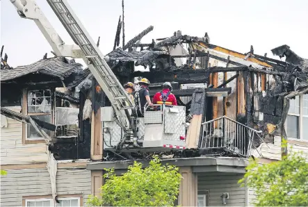  ?? GAVIN YOUNG ?? Fire investigat­ors examine an early morning four-alarm fire, which caused extensive damage to a condo complex in Inglewood on Wednesday. More than 200 residents were able to evacuate safely from the blaze, which took 25 fire department trucks to extinguish.