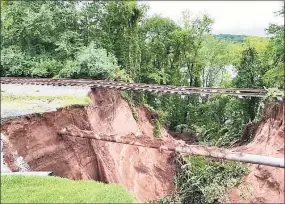  ?? IAFF Local 4662 / Contribute­d photo ?? A massive sinkhole opened up following storm Ida leaving the railroad tracks in the air near the 13th hole at the TPC at River Highlands golf course in Cromwell.