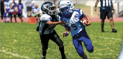  ??  ?? El Centro Trojans’ Jesus Cesena (left) attempts to make a tackle against a ball carrier during a home American Youth Football game against the Lake Havasu Chiefs on Saturday afternoon in El Centro.