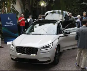  ?? (Bloomberg News/Patrick T. Fallon) ?? Attendees view a Ford Motor Co. Lincoln brand 2020 Corsair Grand Touring hybrid sport utility vehicle displayed during a reveal event ahead of the Los Angeles Auto Show in November.