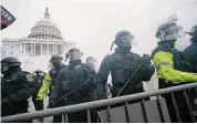  ?? Julio Cortez/Associated Press ?? Police stand guard after holding off rioters who tried to break through a police barrier at the Capitol in Washington, on Jan. 6, 2021. New London submarine engineer Jeremy Baouche was sentenced for his role in the Jan. 6 riot Wednesday, according to federal officials.