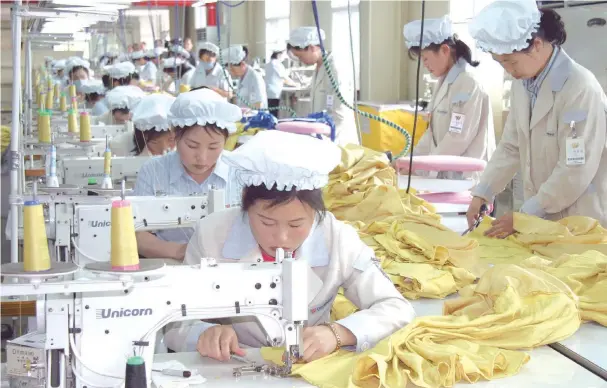  ??  ?? North Korean workers sew clothing at South Korean clothing company Shinwon Corp.’s operations at the Gaeseong Industrial Complex in North Korea. — Bloomberg photo by Heejin Koo