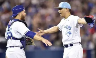  ?? FRANK GUNN, THE CANADIAN PRESS ?? Toronto Blue Jays reliever Roberto Osuna and catcher Russell Martin (left) celebrate their 7-3 win over the Chicago White Sox during ninth inning American League baseball action in Toronto, Sunday.