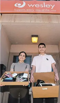  ?? CATHIE COWARD THE HAMILTON SPECTATOR ?? Jasmine and Nicolas Rocci with a boxful of donated phones and tablets. The siblings collected the used devices for homeless people to help them access Telehealth, keep in contact with doctors and to help look for work.