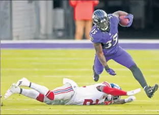  ??  ?? FACE-PLANT: Gus Edwards, one of three Ravens with at least 75 rushing yards Sunday, eludes the tackle of Giants safety Jabrill Peppers.