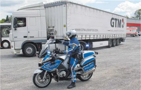  ?? FOTOS CHRISTOPH WARTENBERG: ?? Motorradfa­hrer der Polizei lotsen die Lastzüge auf den Meßkircher Stadthalle­nvorplatz.