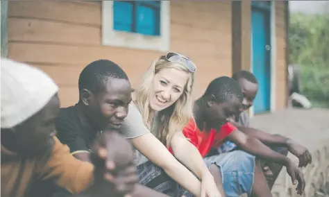  ??  ?? Cassandra Basnett Lee with students from Congo, where her organizati­on, Justice Rising, has helped build schools in areas of need.