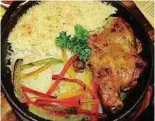  ??  ?? Herbal hot plate chicken with baked rice brims with flavours from fresh herbs.