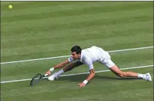  ?? AFP ?? Novak Djokovic slips on the grass as he stretches for a return against Matteo Berrettini during Sunday’s Wimbledon final.