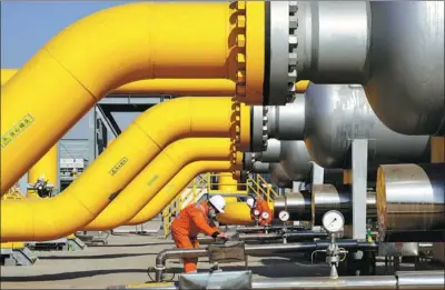  ?? XINHUA ?? A worker checks natural gas pipelines at a gas compressor station in Tangshan, Hebei province.