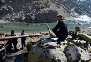  ??  ?? Des policiers afghans posent près de vieux chars soviétique­s, utilisés pendant une guerre (19791989) qui reste dans toutes les mémoires, dans le Panshir, en février 2019.