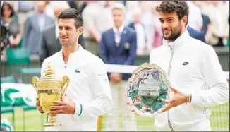  ??  ?? Serbia’s Novak Djokovic holds the winner’s trophy, with Italy’s Matteo Berrettini standing beside him with the runners-up trophy for the men’s singles final match on day thirteen of the Wimbledon Tennis Championsh­ips in London, Sunday, July 11, 2021. (AP)