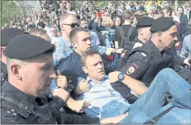  ?? THE ASSOCIATED PRESS ?? Alexei Navalny, center, an opposition leader and foe of Russian President Vladimir Putin, is removed by Russian police officers Saturday from Moscow’s Pushkin Square, one site of demonstrat­ions against Putin ahead of his inaugurati­on. About...