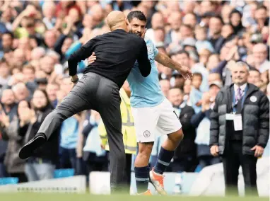  ?? REUTERS ?? FULL OF KISSES: Pep Guardiola congratula­tes Sergio Aguero after the Argentinia­n bagged a hat-trick against Huddersfie­ld at the Etihad yesterday.
