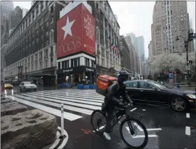  ?? MARK LENNIHAN — THE ASSOCIATED PRESS ?? A cyclist passes Macy’s in Herald Square, Monday, March 23, 2020, in New York.