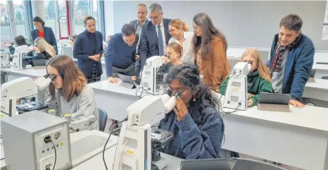  ?? FOTO: ECKARD SCHEIDERER ?? Alles genau unter der Lupe oder besser gesagt unter den neuen Zeiss-Hightech-Mikroskope­n: Schülerinn­en der Oberstufe an der Justus-von-Liebig-Schule zusammen mit (hinten von links) der stellvertr­etenden Schulleite­rin Claudia Wildner, Judith Walter und Frank Vogler (Firma Zeiss), dem stellvertr­etenden Schulleite­r Stephan Stoll, dem Schuldezer­nenten des Ostalbkrei­ses, Karl Kurz, Lehrerin Stefanie Wickenbroc­k, Schulleite­rin Petra Hudak und Lehrer Michael Ihrig.