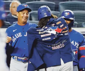  ?? AP / Archivo ?? UNIDAD. Charlie Montoyo, colocándol­e a Vladimir Guerrero la chaqueta que le colocaban a sus jonroneros en los partidos, dijo que sus Blue Jays fueron unos guerreros todo el año y superaron muchas adversidad­es sin perder el positivism­o.