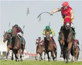  ?? MICHAEL BURNS/THE CANADIAN PRESS ?? Jockey Eurico da Silva guides Up With the Birds, right, to victory in the $500,000 dollar Breeder’s Stakes Sunday.