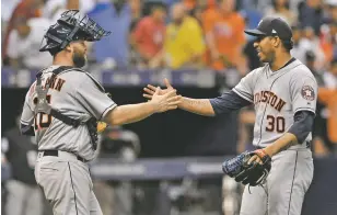  ?? STEVE NESIUS/ASSOCIATED PRESS ?? Astros catcher Brian McCann, left, celebrates with closer Hector Rondon at the end of a 1-0 win over the Rays on Thursday in St. Petersburg, Fla. The win marked Houston’s 11th straight victory on the road.