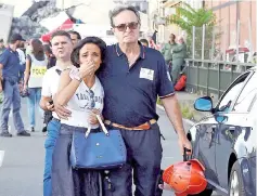  ??  ?? A woman cries being embraced by a fire fighter as she leaves the site of the collapsed Morandi Bridge.