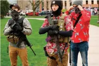  ?? JEFF KOWALSKY AFP/GETTY IMAGES ?? Armed protesters in Hawaiian shirts on April 30 take part in a demonstrat­ion outside the state capitol in Lansing, Mich.