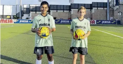  ?? VILLARREAL CF ?? Dani Serrano, izquierda, y Jorge Beltrán, derecha, posan con un balón en las instalacio­nes deportivas de Miralcamp.